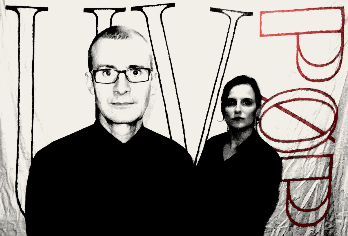 UV Pop band photo in front of a large hand-painted UV PØP sign